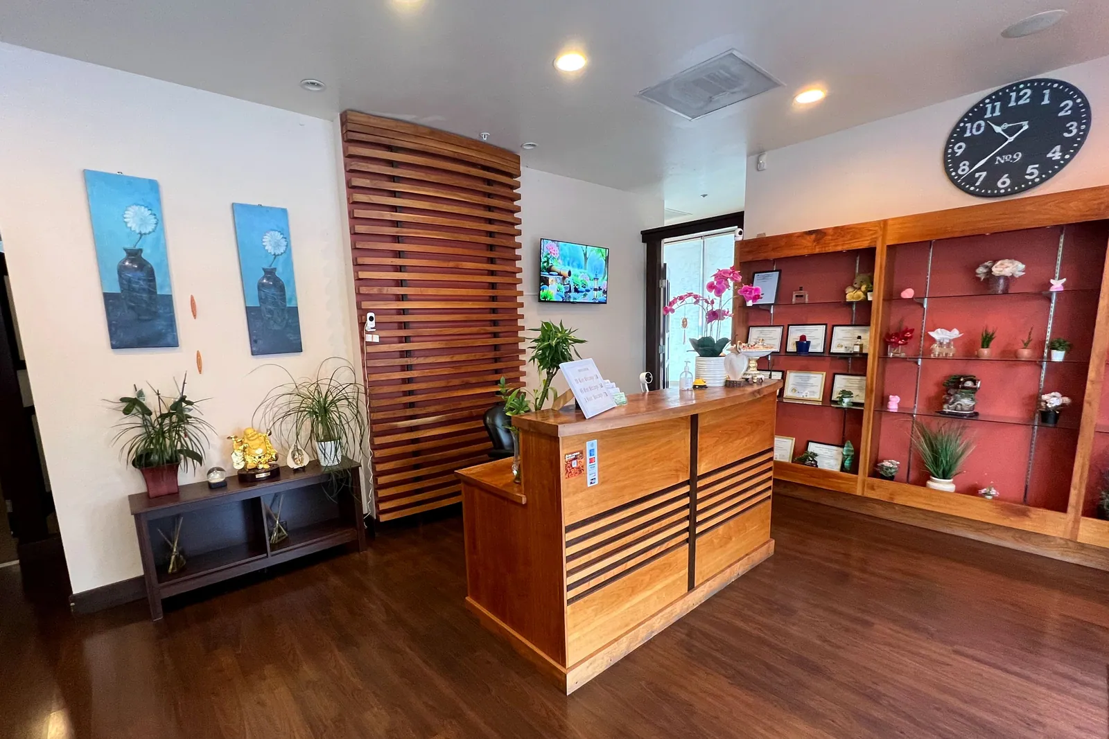 The reception area at Butterfly Day Spa, with a cherry-wood desk and display of orchids and gifts